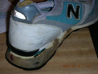 2231 62j. a very old running shoe falling apart