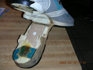 2233 62j. a very old running shoe falling apart