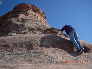 245 6ug. Arches National Park - hiker climbing near Delicate Arch