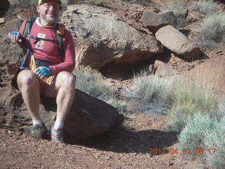 51 7j7. Canyonlands Lathrop hike - Adam sitting on neat rock (tripod)