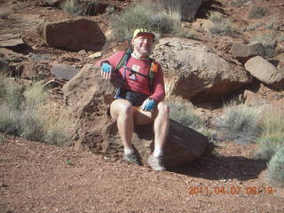 53 7j7. Canyonlands Lathrop hike - Adam sitting on neat rock (tripod)