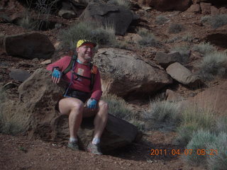 55 7j7. Canyonlands Lathrop hike - Adam sitting on neat rock (tripod)