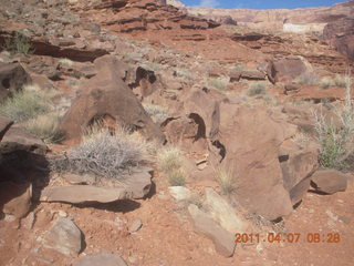 Canyonlands Lathrop hike - Adam sitting on neat rock (tripod)