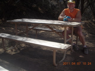 129 7j7. Canyonlands Lathrop hike/run - Adam at riverside picnic table at (tripod)