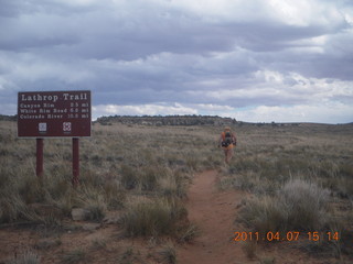 264 7j7. Canyonlands Lathrop hike/run - Adam running with sign