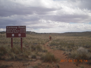 265 7j7. Canyonlands Lathrop hike/run - Adam running with sign
