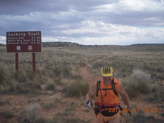 269 7j7. Canyonlands Lathrop hike/run - Adam running with sign