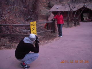 14 7sf. Zion National Park - pre-dawn Riverwalk - icy warning signs - Gokce taking a picture of Olga