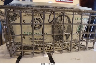 two dollar bill in the pizza place tip basket