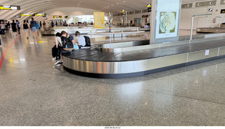 34 a2y. Spain - barcelona to bilbao flight - people sitting on baggage-claim belt